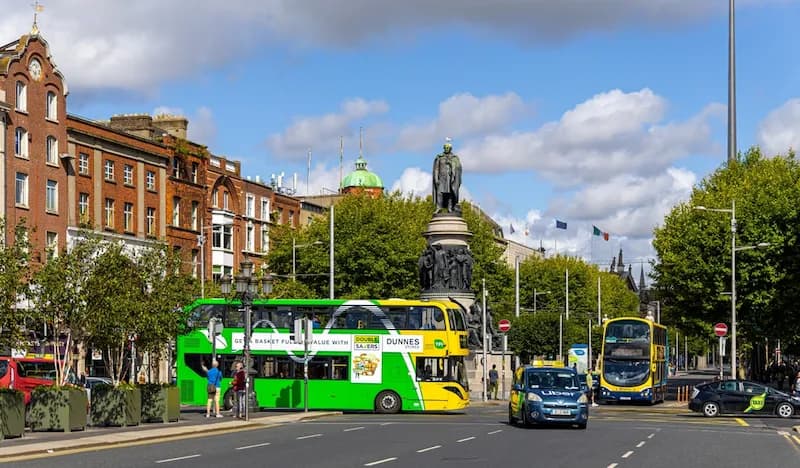 Un autobús de dos pisos amarillo y verde circula por el tráfico en Dublín, Irlanda. Exploremos algunas de las mejores escuelas culinarias en Irlanda.
