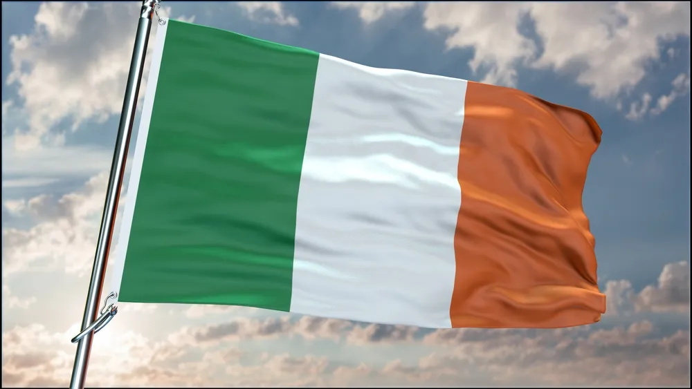 La bandera de Irlanda ondeando al viento contra un cielo lleno de nubes. Irlanda alberga algunas de las mejores escuelas culinarias del mundo.