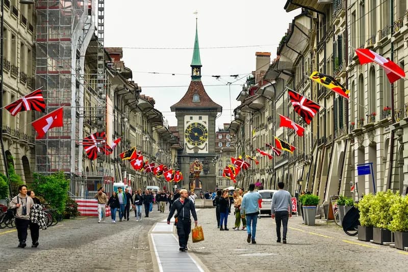 Turistas y residentes pasean por el casco antiguo de Berna con la torre del reloj Zytglogge al fondo. Las escuelas culinarias de Suiza ofrecen diversas certificaciones y títulos.