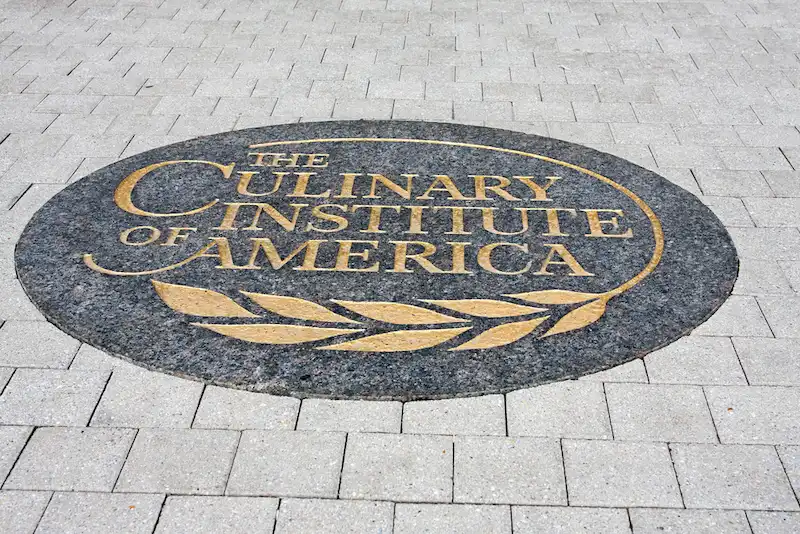 The logo of the Culinary Institute of America (CIA) among paving stones inside one of its campuses. The CIA is one of the top culinary schools in the world.