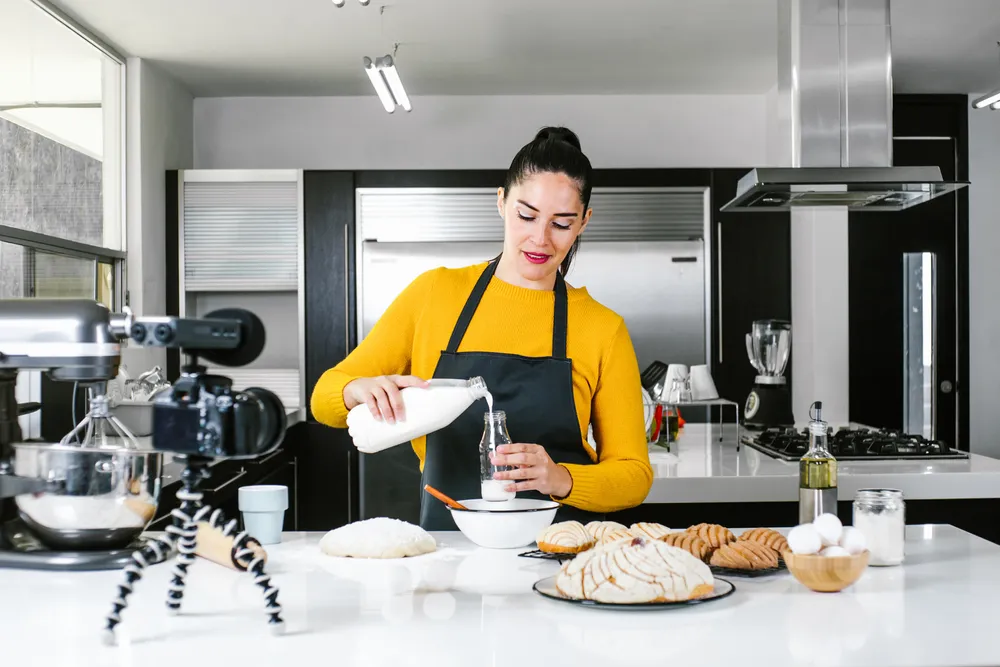 A YouTube content creator filming a cooking video in a restaurant kitchen. YouTube marketing for restaurants includes a set of basic steps to follow as discussed in this article.