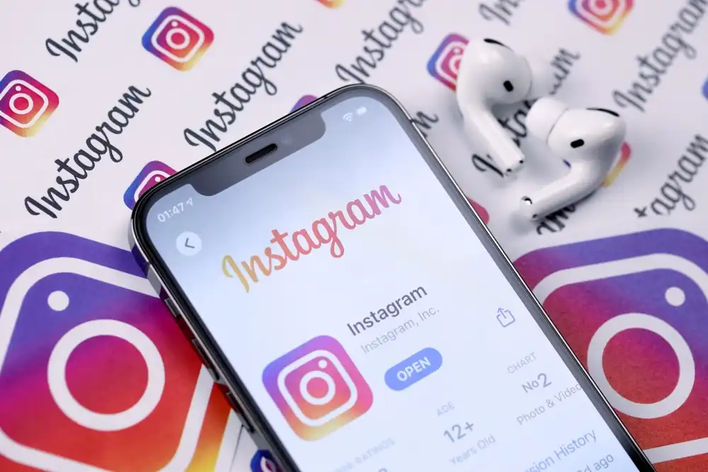 A mobile phone with the Instagram app loaded. In the background a collage of Instagram images. Digital marketing with Instagram requires a plan, which includes understanding your audience, setting clear goals, and creating engaging content on a consistent basis.