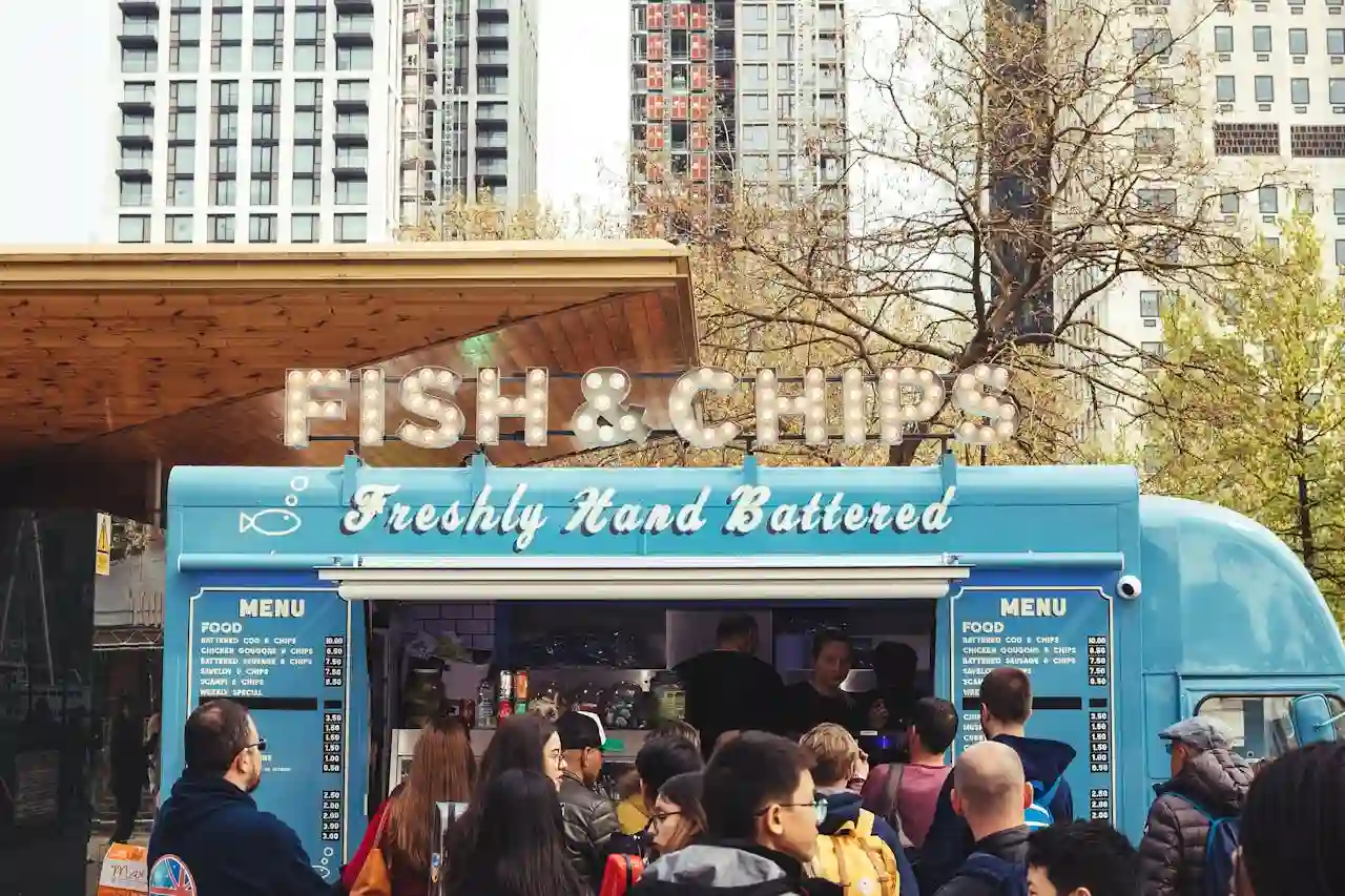 Many people waiting in line to order food from a food truck. Renting a food truck instead of purchasing one can be a cost-effective solution for aspiring food entrepreneurs.