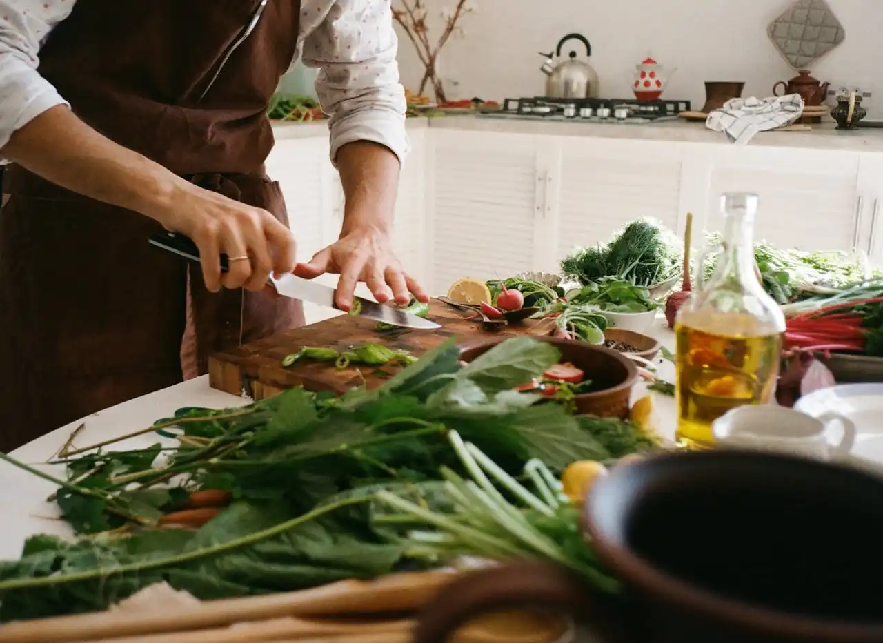 Chef privado en la cocina cortando verduras en una tabla de cortar