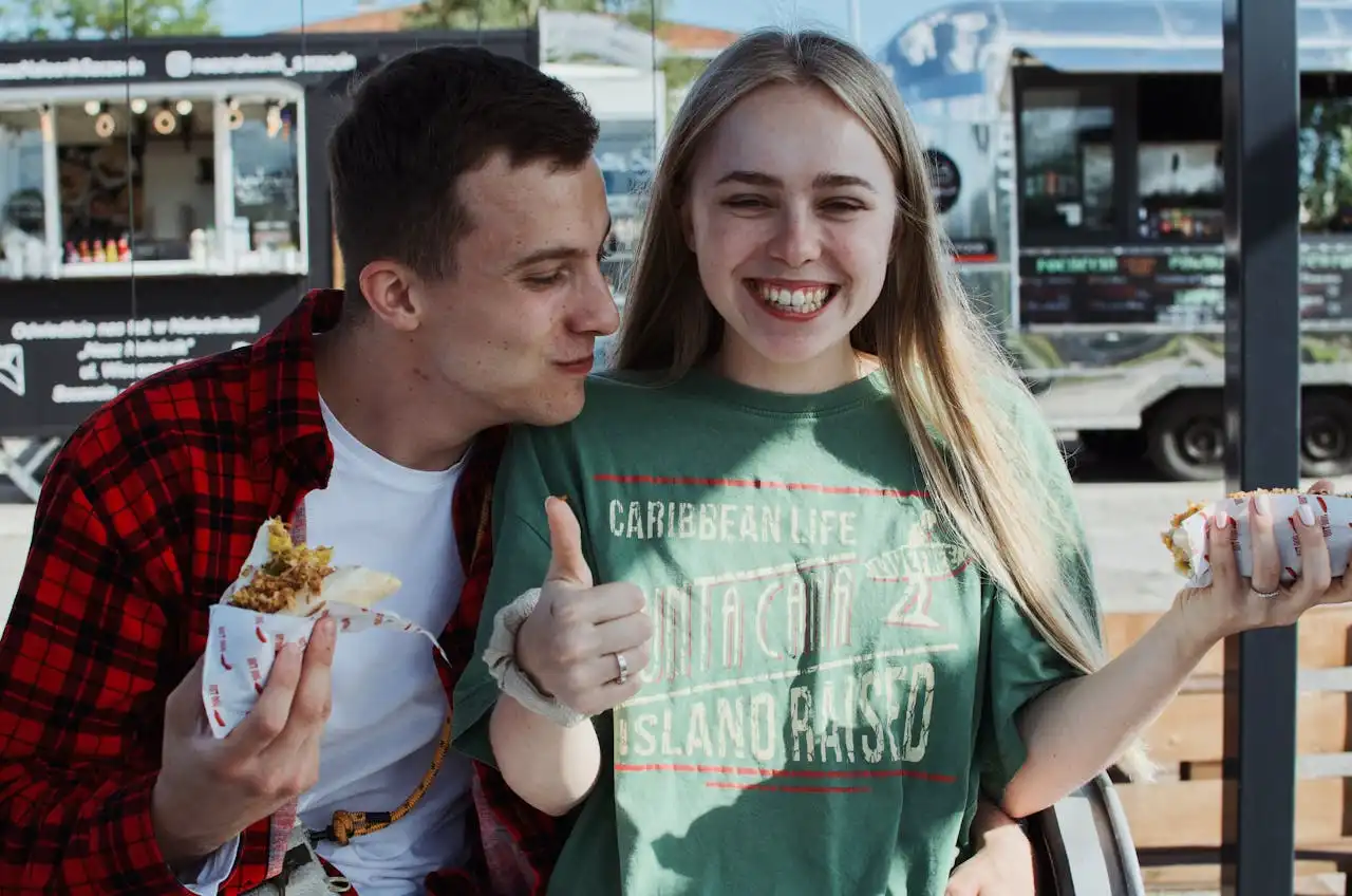 A young man and young woman enjoying food from a food truck in Austin, TX