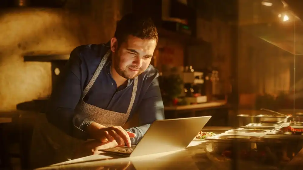 Chef working on his laptop as he creates a business plan for his food truck