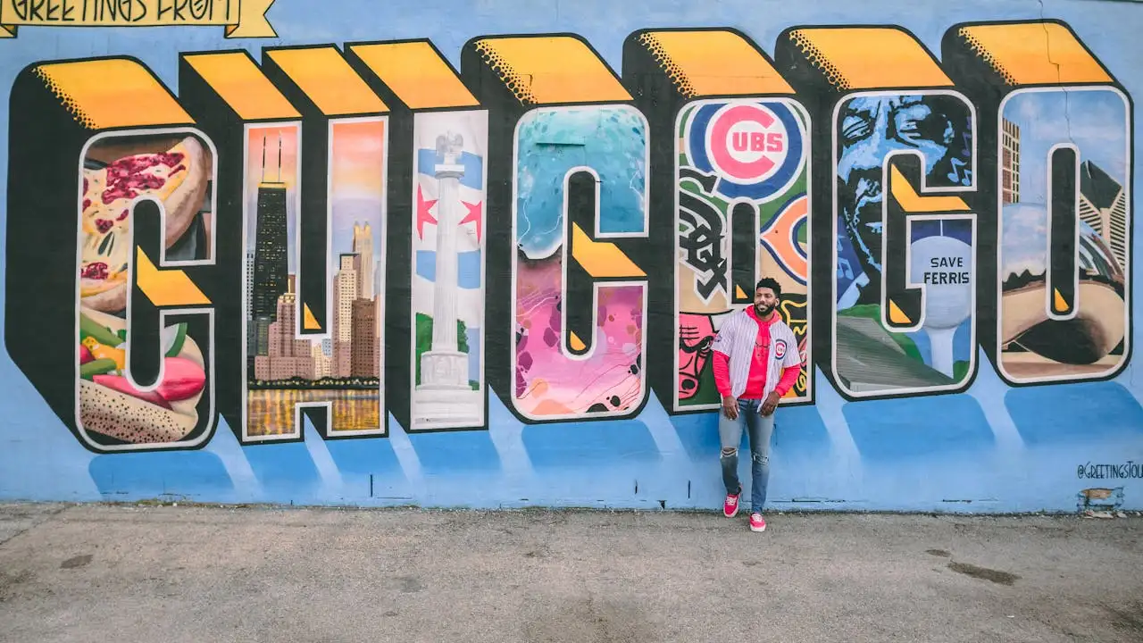 A Chicagoan leans against a wall with a giant mural that says Chicago. How to start a food truck business in Chicago, including information about permits, licenses, and more