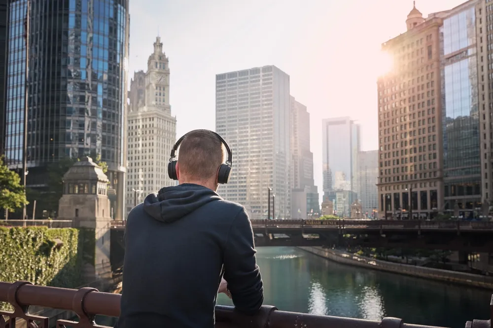 A Chicago food truck owner wearing a wireless headset and looking out at the Chicago river as he plans his day for his food truck business in Chicago, IL.