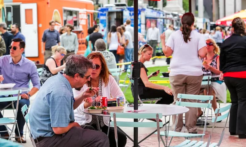 Food truck diners enjoying their meals outside a food truck in Denver, Colorado.