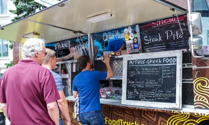 Patrons of a food truck in Denver, Colorado wait in line as they decide what to order.