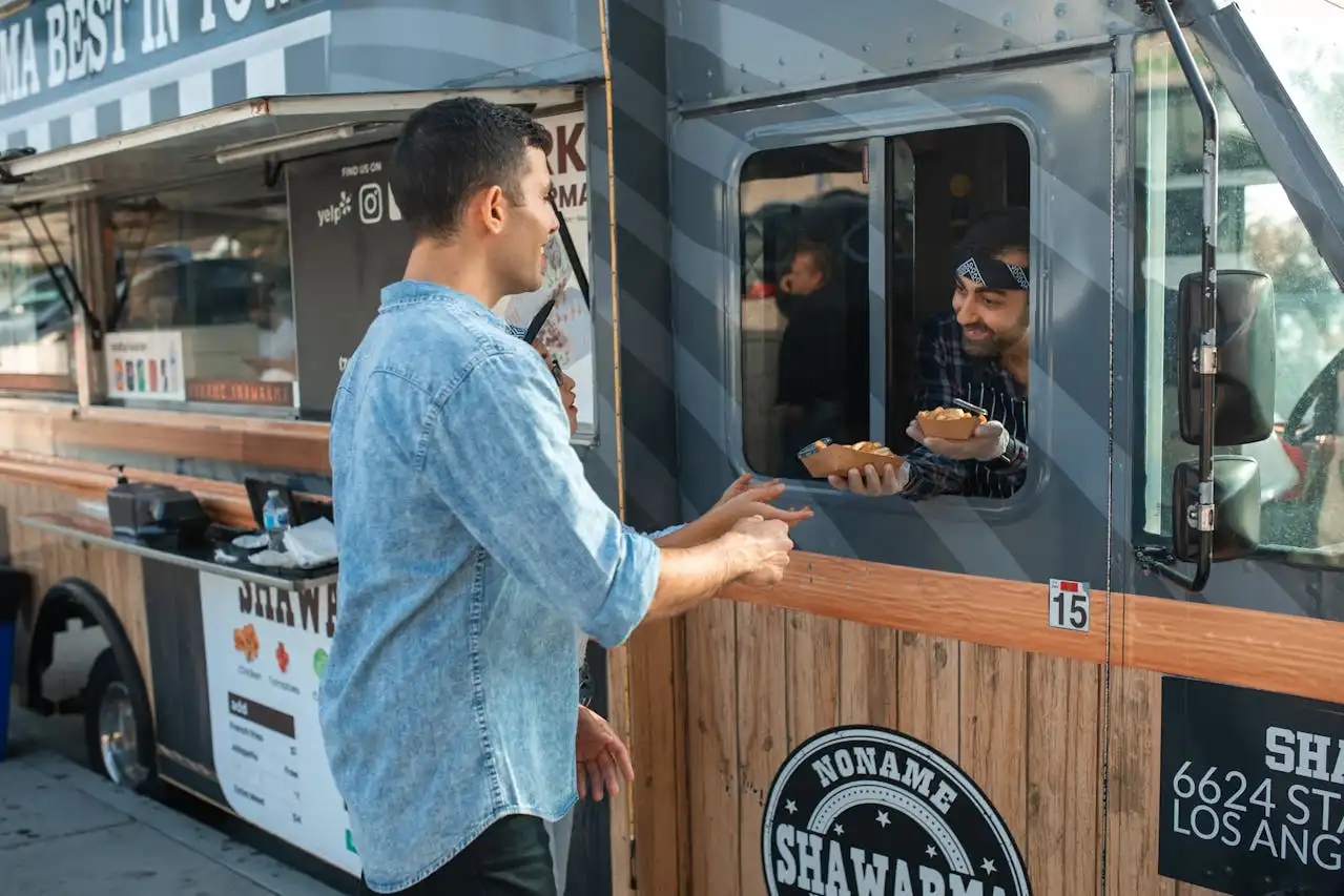 A customer receiving food from a food truck parked in Los Angeles