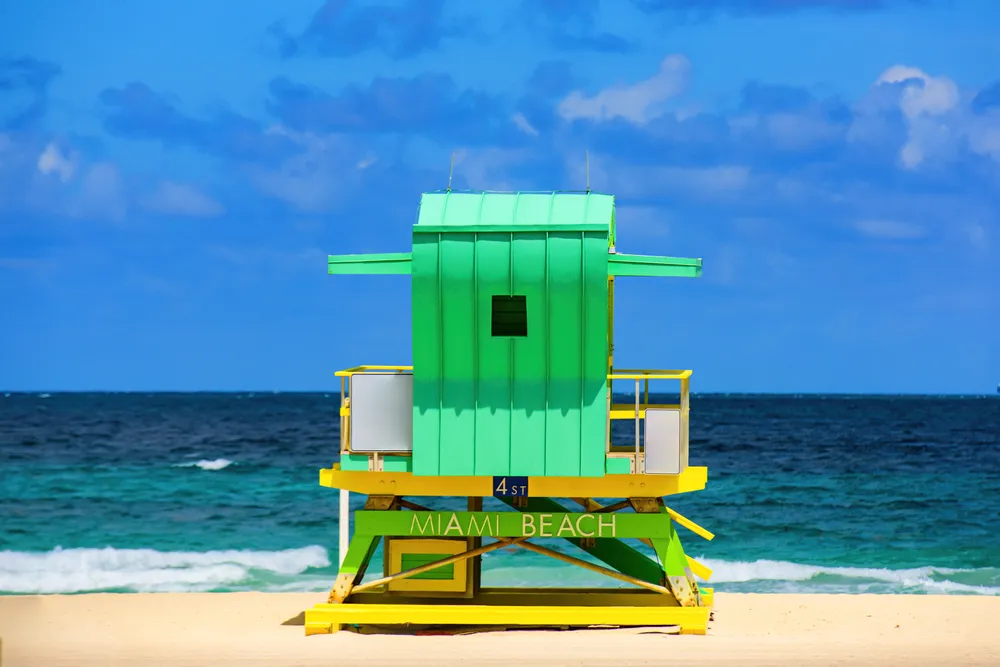 A brightly colored lifeguard tower on a Miami beach, symbolizing the vibrant culture and outdoor lifestyle of the city. Your Miami food truck could be serving customers right by the beach.