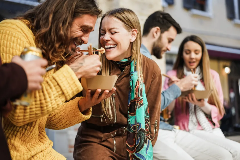 A group of friends and couples enjoying food from a food truck in Miami.