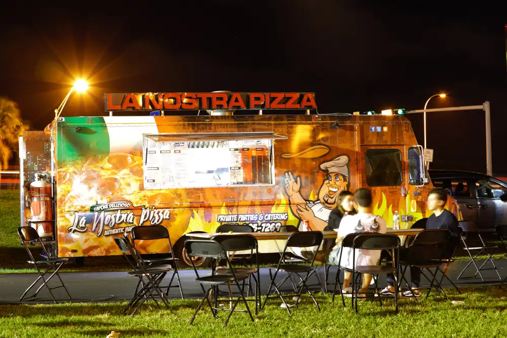 Outdoor seating area next to a food truck in Miami, providing a comfortable place for customers to enjoy their meals.
