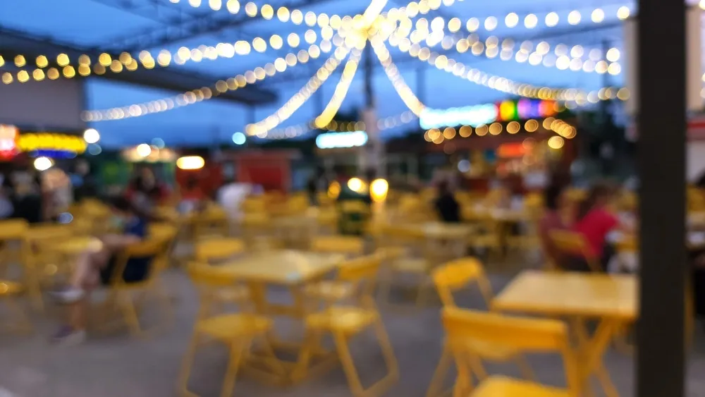 A blurred image of string globe lights at a food truck even in Orlando, FL. Be mindful of employee hours and pay when building your crew for your food truck in Orlando.