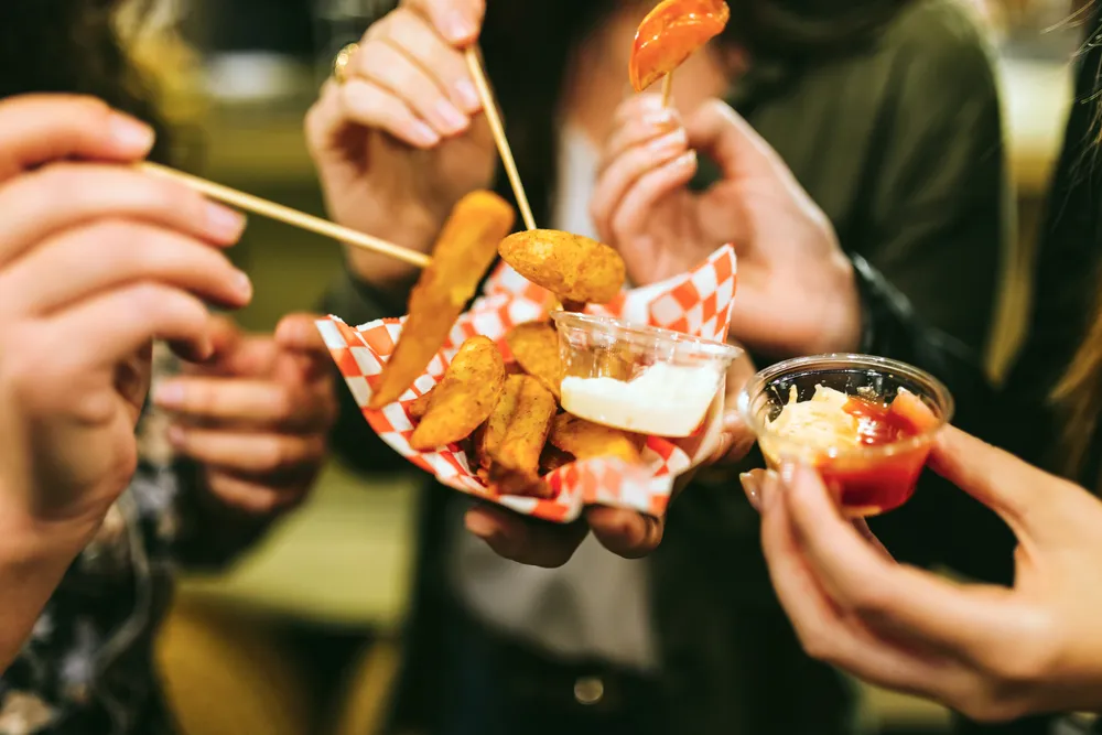 A group of people gathered around a food truck in Phoenix, Arizona, enjoying a variety of delicious street food.