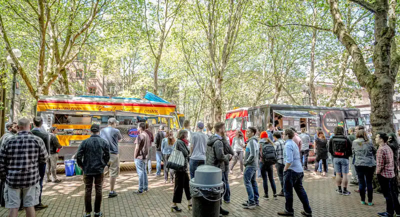 A caravan of food trucks in Seattle park ready to serve customers. Food trucks are a popular and growing trend in Seattle, offering diverse and convenient dining options.