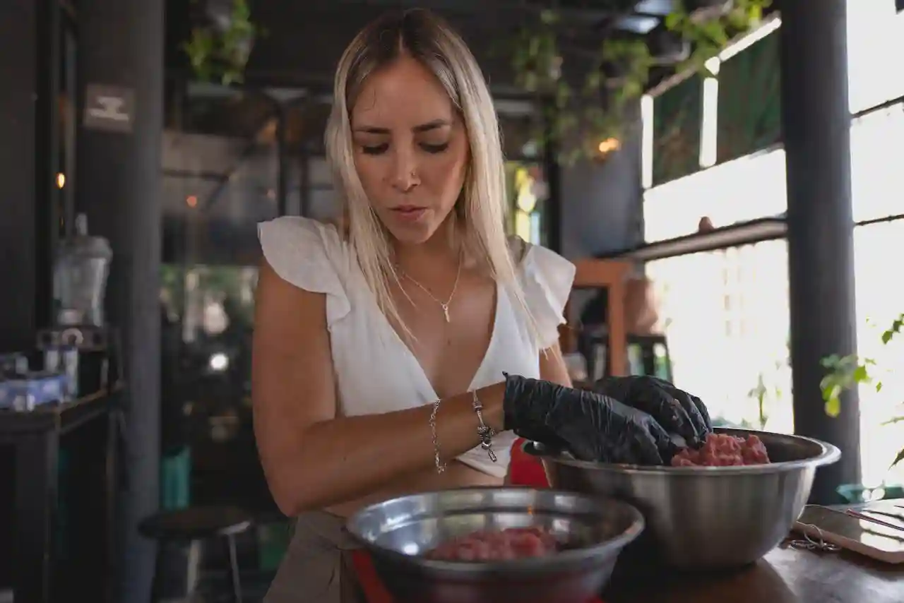 Una chef preparando carne para su restaurante pop up