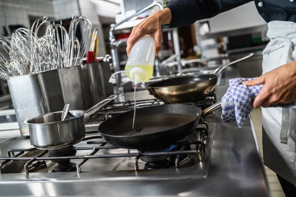 Un cocinero prepara comida en una cocina comercial. Se requiere una cocina comercial si planeas abrir una cocina fantasma en DoorDash.