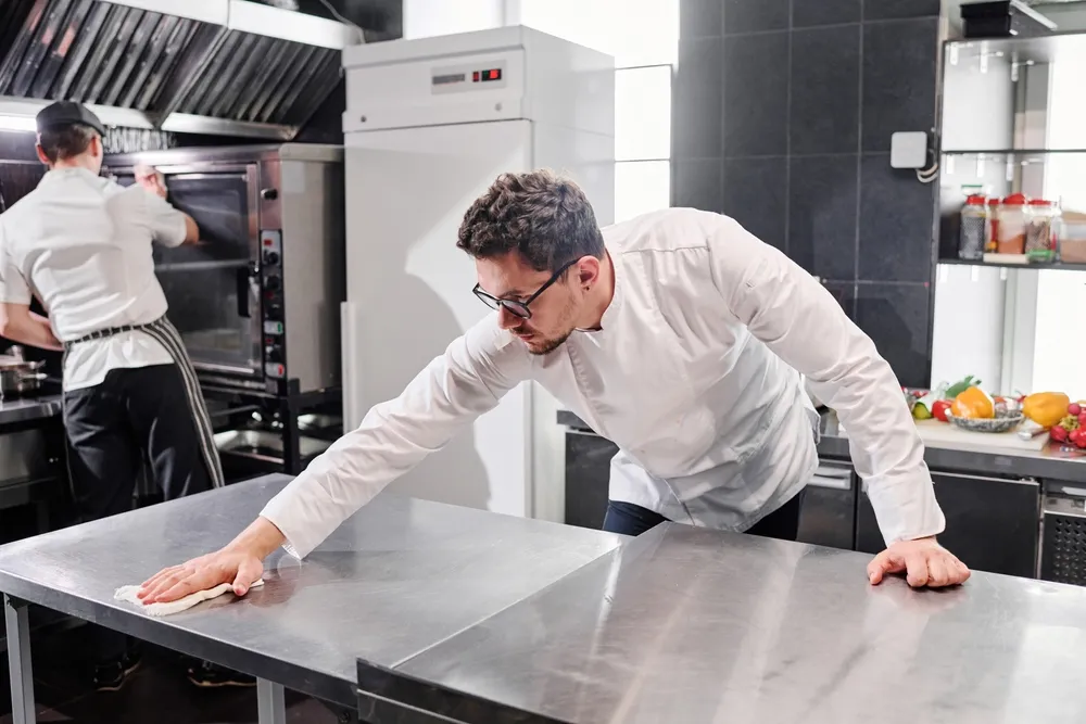 Restaurant manager and chef inspect and clean used commercial kitchen equipment that was recently purchased for their commercial kitchen. Buying used commercial kitchen equipment can save restaurant owners thousands of dollars when opening a new restaurant.