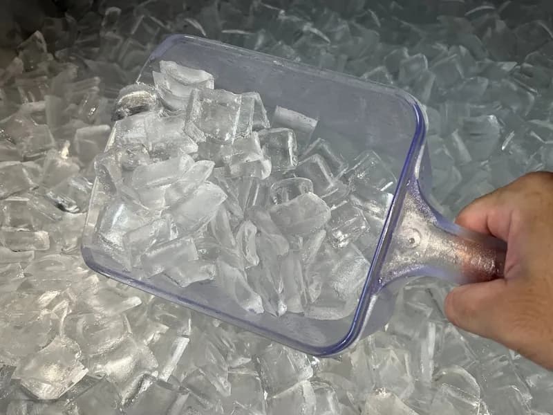 A cook scoops ice from a commercial ice machine. Buying used commercial kitchen equipment like ice machines can be risky due to potential hygiene issues.