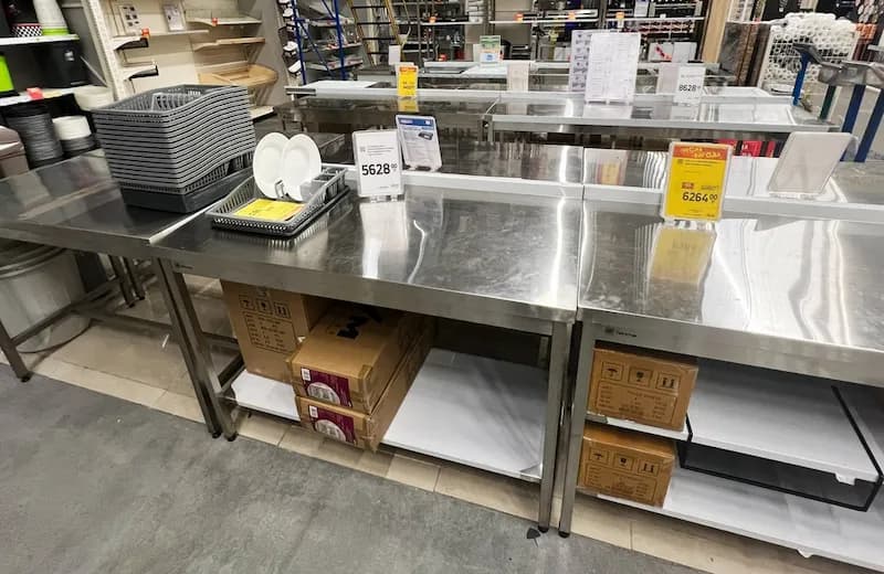 Stainless steel commercial kitchen prep tables and shelving units. Buying used commercial kitchen equipment like these stainless steel tables can save you money when opening a new restaurant.