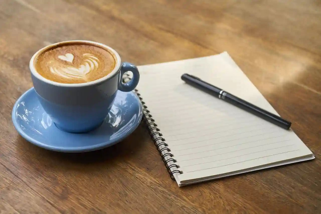 Culinary school was the right choice for Casey Bumpsteed, but learning on the job has its merits. Image of cup of coffee with a heart design, a notepad, and a pen, all on a wooden table