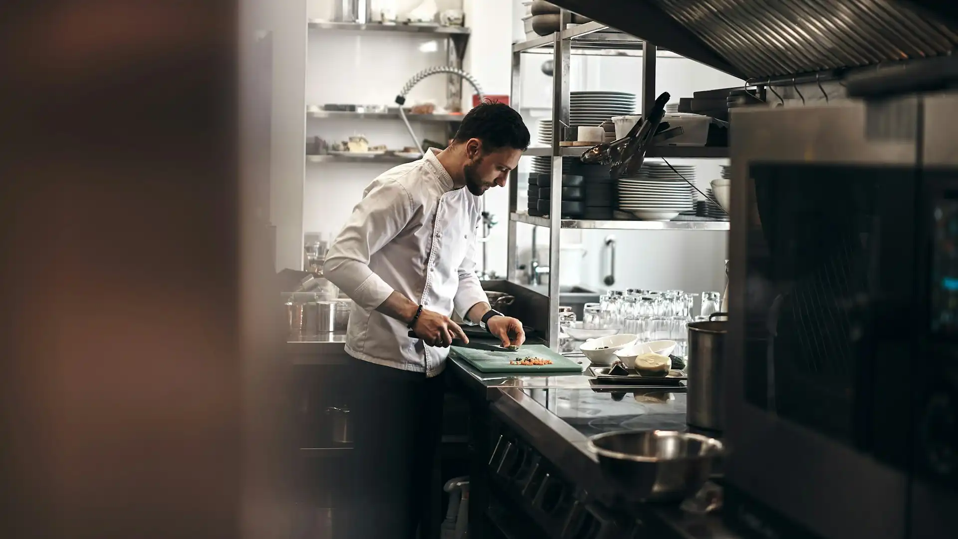 Understanding what is ghost kitchen is important in learning how to start a ghost kitchen. As shown in this image of a ghost kitchen with a chef preparing food for delivery.