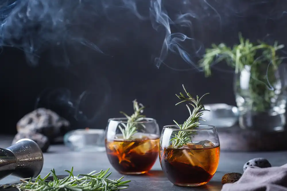 What is mixology? What makes someone the ultimate mixologist? A mixologist is a bartender who specializes in making cocktails and mixed drinks. As shown in this image of a drink infused with rosemary and smoke.
