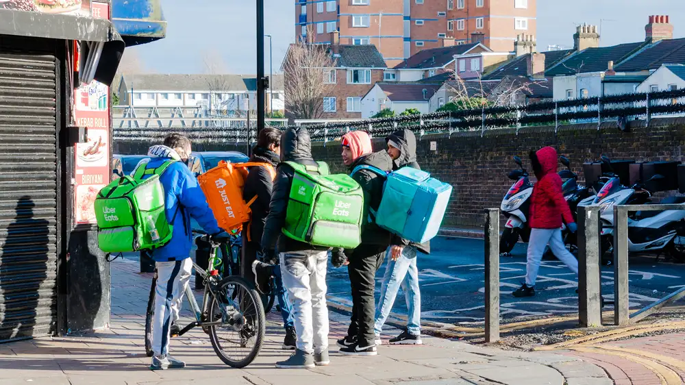 Wondering how much are commission fees for Deliveroo? They range from 15% to 30% depending on the restaurant's location and the type of service. As shown in this image of food delivery drivers in London using the food delivery apps Deliveroo and Uber Eats to deliver food to customers.