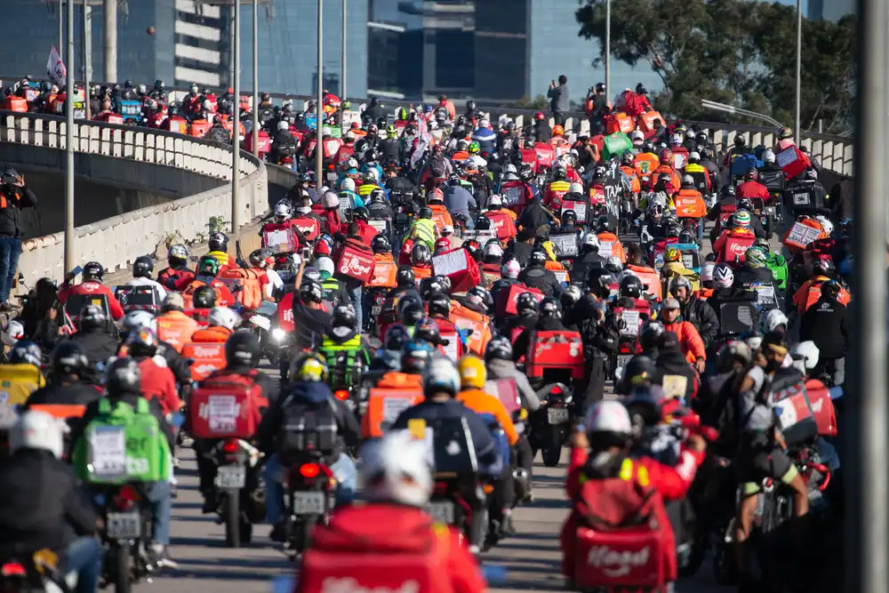 Rappi, DiDi Food, iFood, and Uber Eats are popular food delivery app in Latin America, as shown in this image of many food delivery operators on the road.