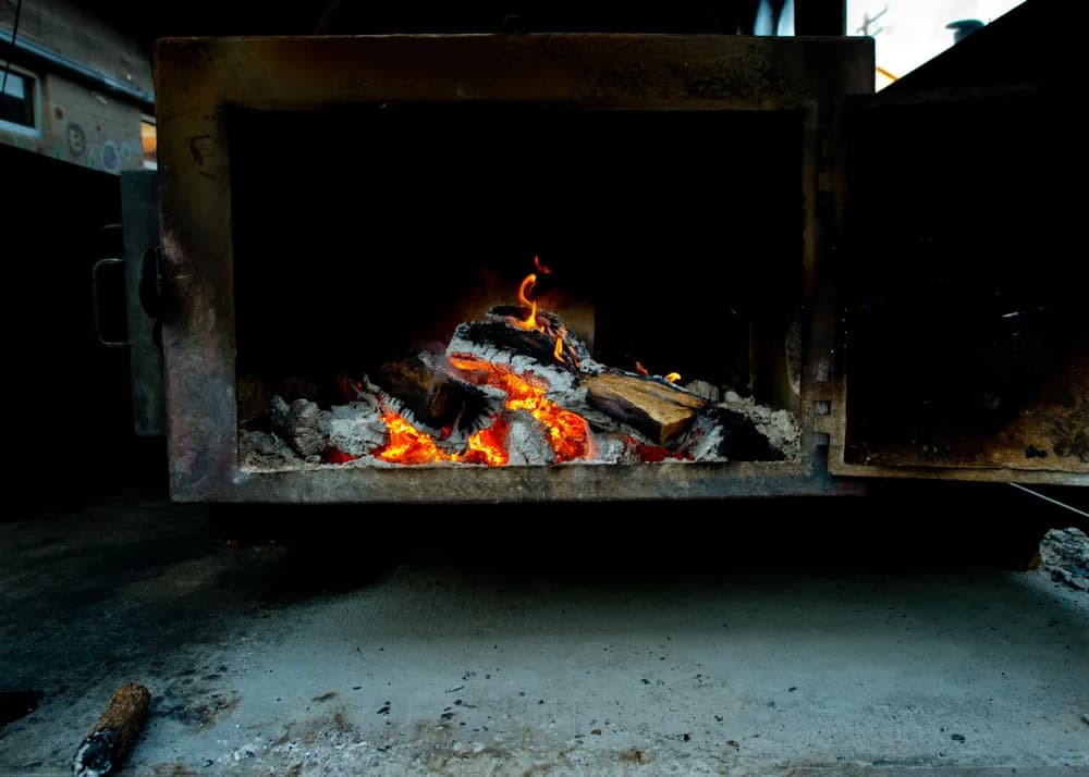 Texas oak being used to smoke brisket at Franklin BBQ in Austin, Texas. The image represents the use of a smoker, although it is not a genuine Aaron Franklin Smokers.