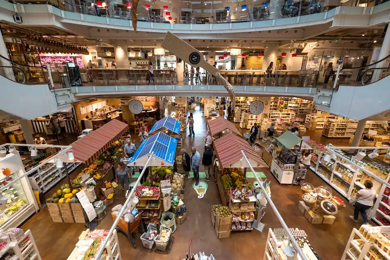 El interior de varios niveles del local Eataly en Milán, Italia. En la primera planta se venden comestibles y otros productos italianos. Los alimentos preparados por Eataly, así como la comida Eataly en general, están disponibles en los patios de comidas de Eataly.