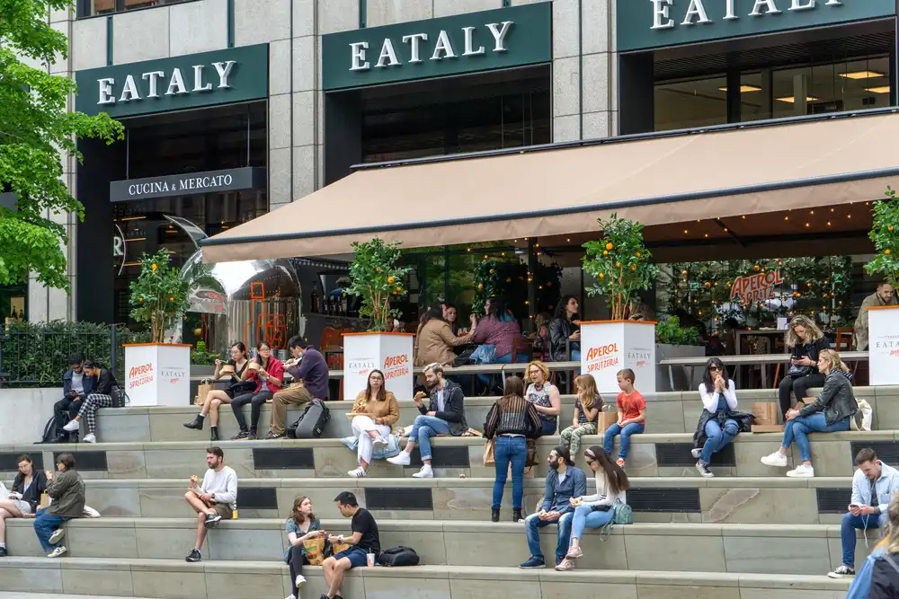 Clientes sentados en las escaleras del local de Eataly en Londres. Eataly se ha convertido en un destino popular para amantes de la gastronomía y entusiastas culinarios de todo el mundo.