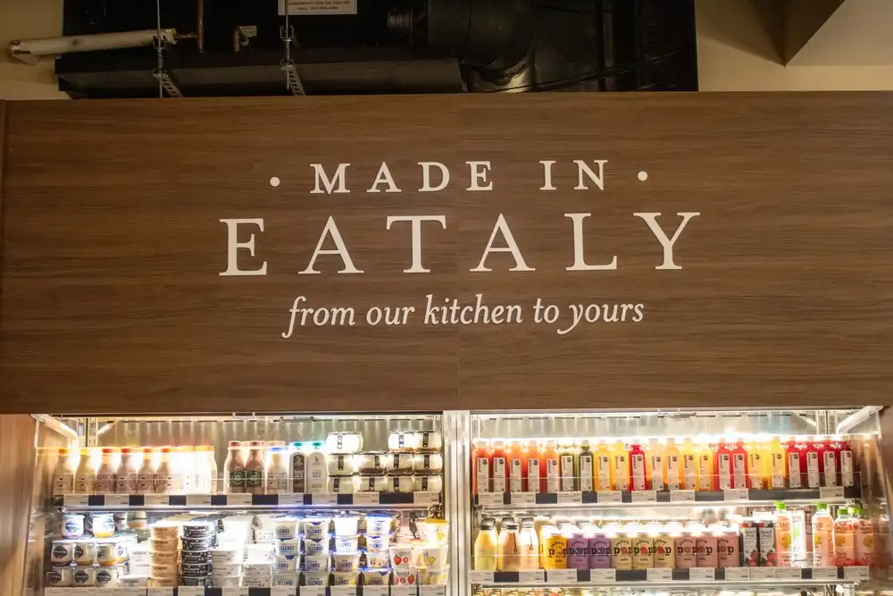 Las palabras 'Hecho en Eataly de nuestra cocina a la suya' están escritas en una pared dentro de la ubicación de Eataly en Nueva York. Eataly abrió su primera ubicación en EE. UU. en la ciudad de Nueva York en 2010.